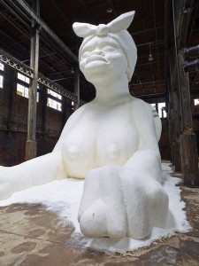 Kara Walker: A Subtlety, or the Marvelous Sugar Baby, an Homage to the unpaid and overworked Artisans who have refined our Sweet tastes from the cane fields to the Kitchens of the New World on the Occasion of the demolition of the Domino Sugar Refining Plant, 2014 Polystyrene foam, sugar Approx. 35.5 x 26 x 75.5 feet (10.8 x 7.9 x 23 m). A project of Creative Time, installation view: Domino Sugar Refinery, Brooklyn, NY, 2014. Photo: Jason Wyche. Artwork © 2014 Kara Walker.