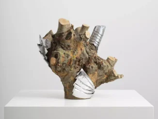 Skulptur aus knorrigem Baumstumpf mit eingearbeiteten Metallelementen aus Aluminium auf weissem Sockel