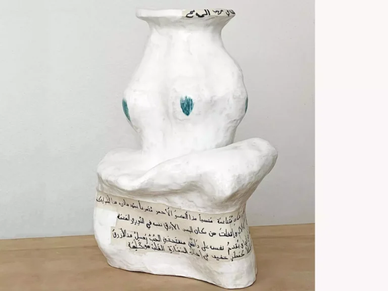 Weisse Keramikskulptur mit organischer Form, arabischer Schrift und türkisfarbenen Akzenten