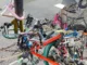 Skulpturale Installation aus ineinander verschlungenen Fahrradrahmen, Ketten und Seilen auf urbanem Pflaster
