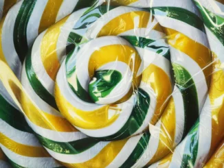 Hyperrealistische Nahaufnahme eines Lollipops mit spiralförmigen Streifen in Gelb, Grün und Weiß