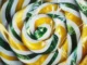 Hyperrealistische Nahaufnahme eines Lollipops mit spiralförmigen Streifen in Gelb, Grün und Weiß